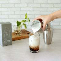 ラテシェイカーで作ったミルクをコーヒーに注ぐ様子